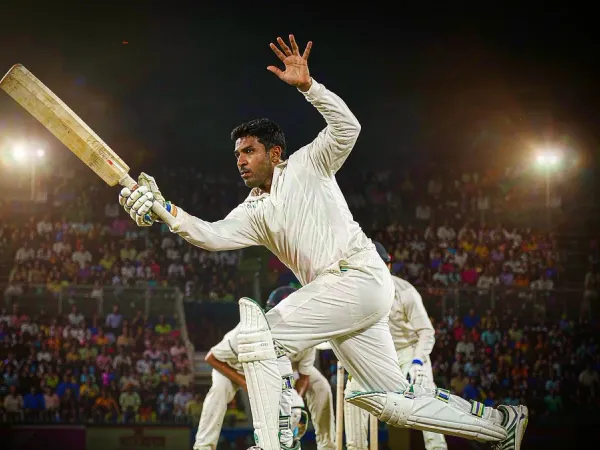 p88 Cricketer in white kit playing a shot under floodlights in a packed stadium