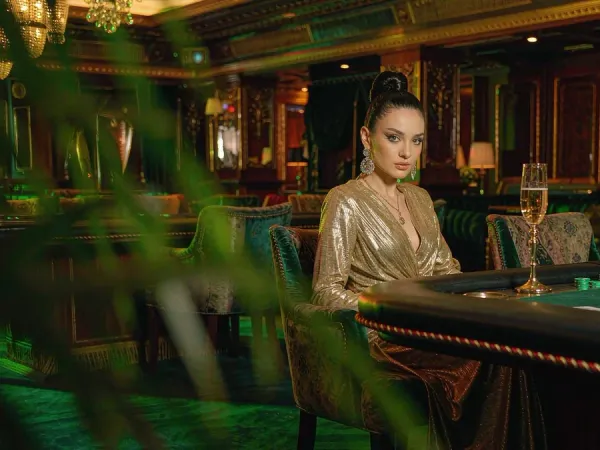 p88 Woman in a gold gown at a baccarat table in a VIP lounge